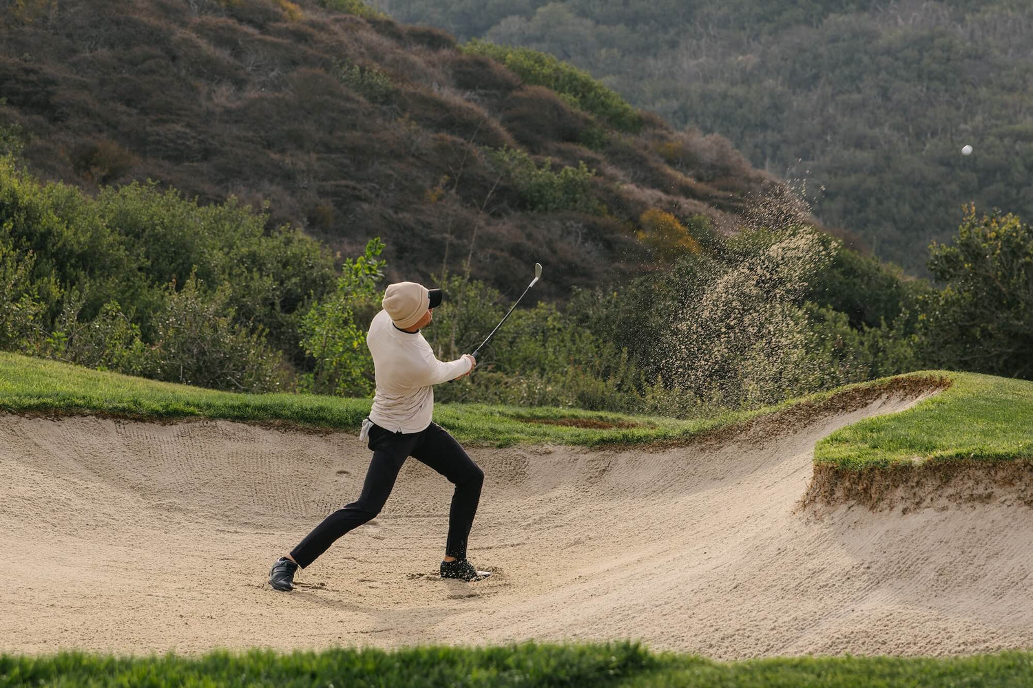 Golfer in Kingsmen Polo playing out of the bunker